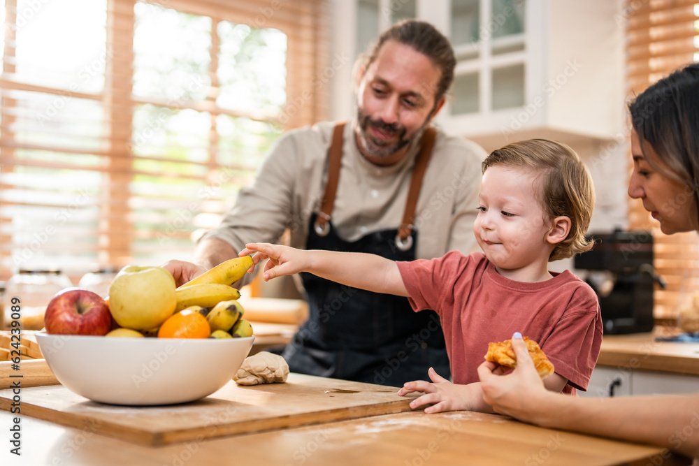 Caucasian attractive couple baking bakery with son in kitchen at home. 