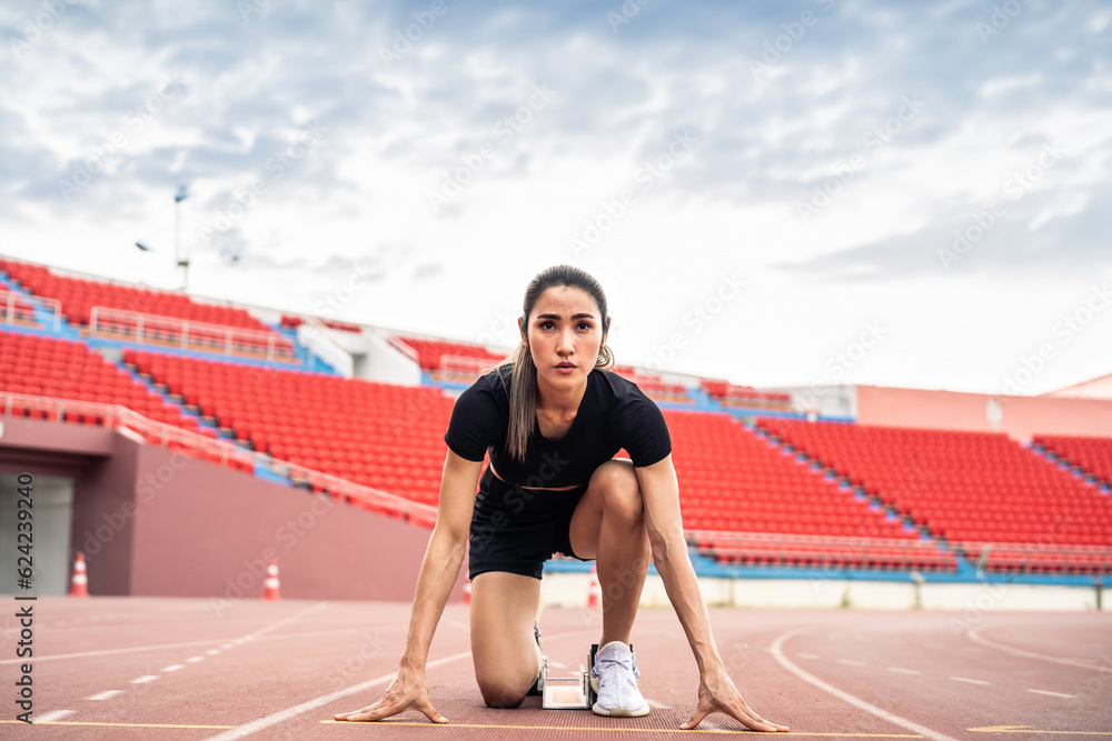 Asian young sportswoman sprint on a running track outdoors on stadium. 