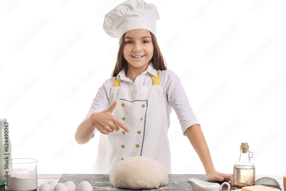 Little baker pointing at dough on table against white background