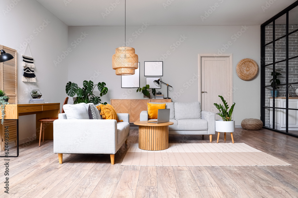 Interior of living room with green houseplants and sofas