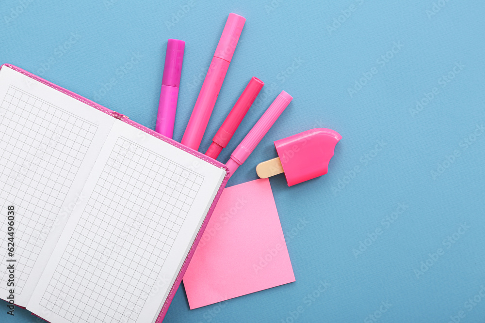 Blank notebook with different stationery on blue background