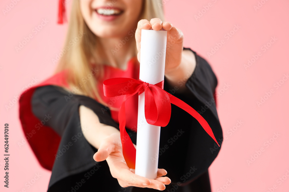 Female graduate student with diploma on pink background, closeup