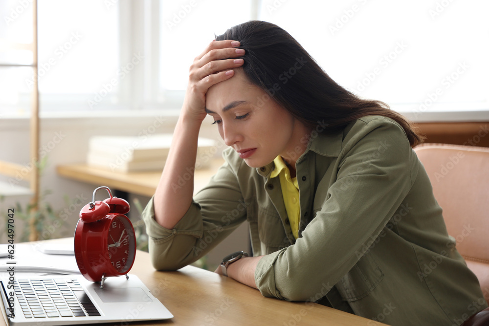 Stressed young businesswoman working under deadline in office