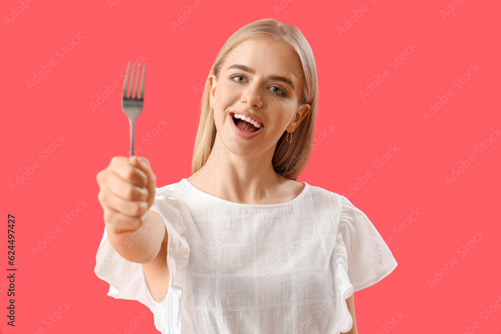 Young woman with fork on red background, closeup