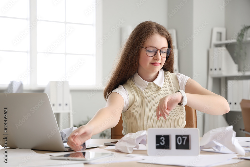 Young businesswoman working under deadline in office