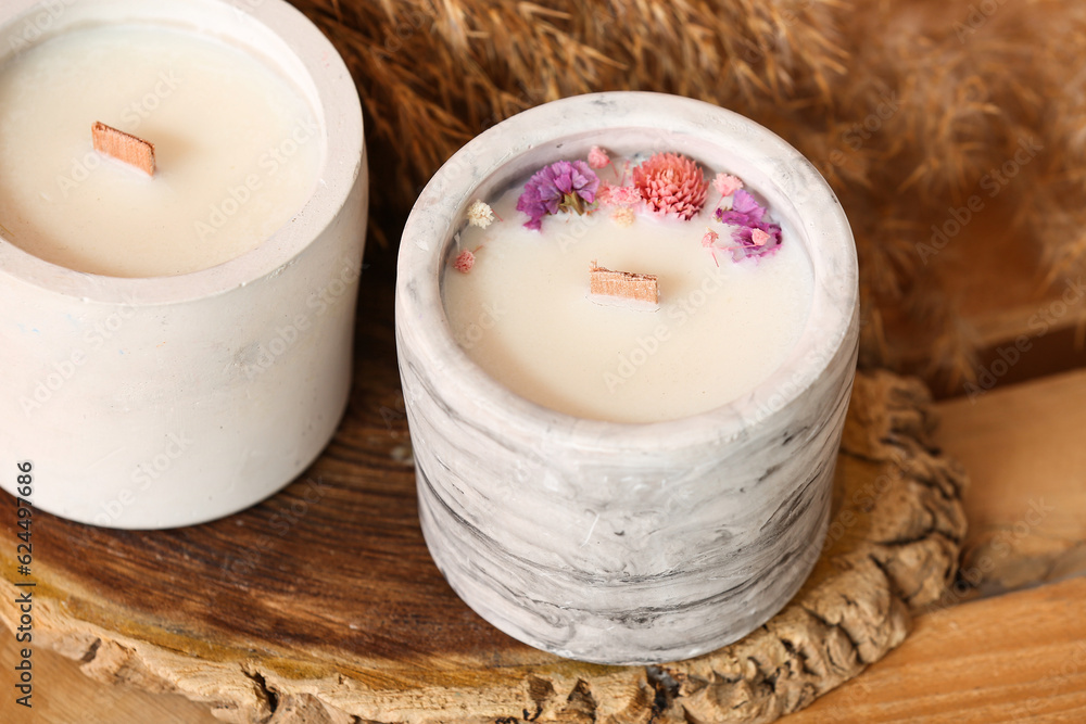 Holders with candles on wooden table, closeup