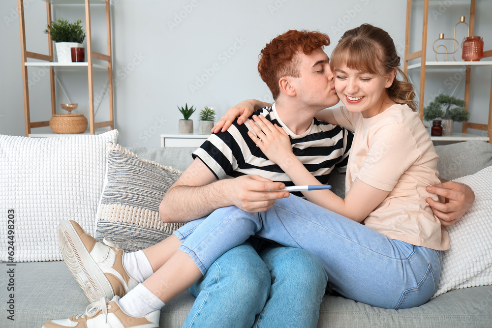 Happy young couple with pregnancy test at home