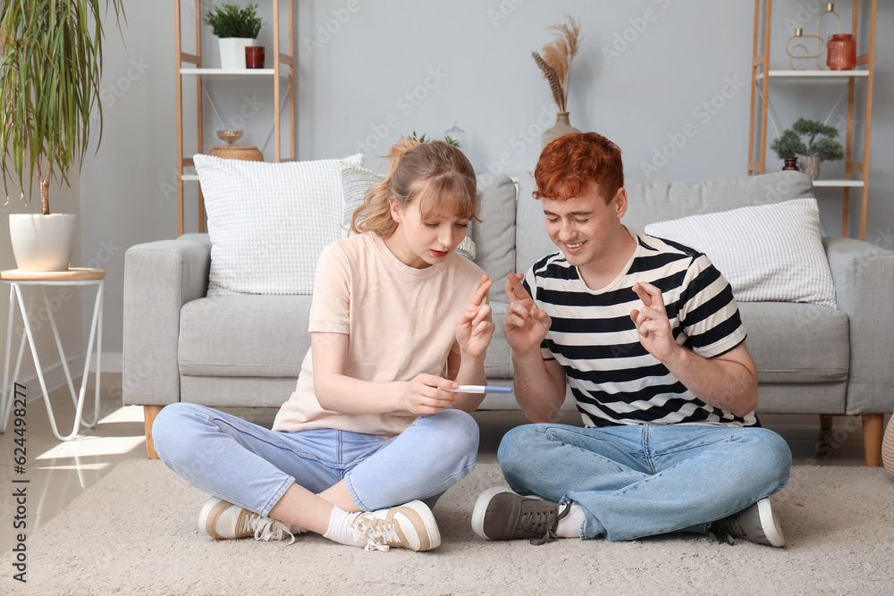 Happy young couple with pregnancy test at home