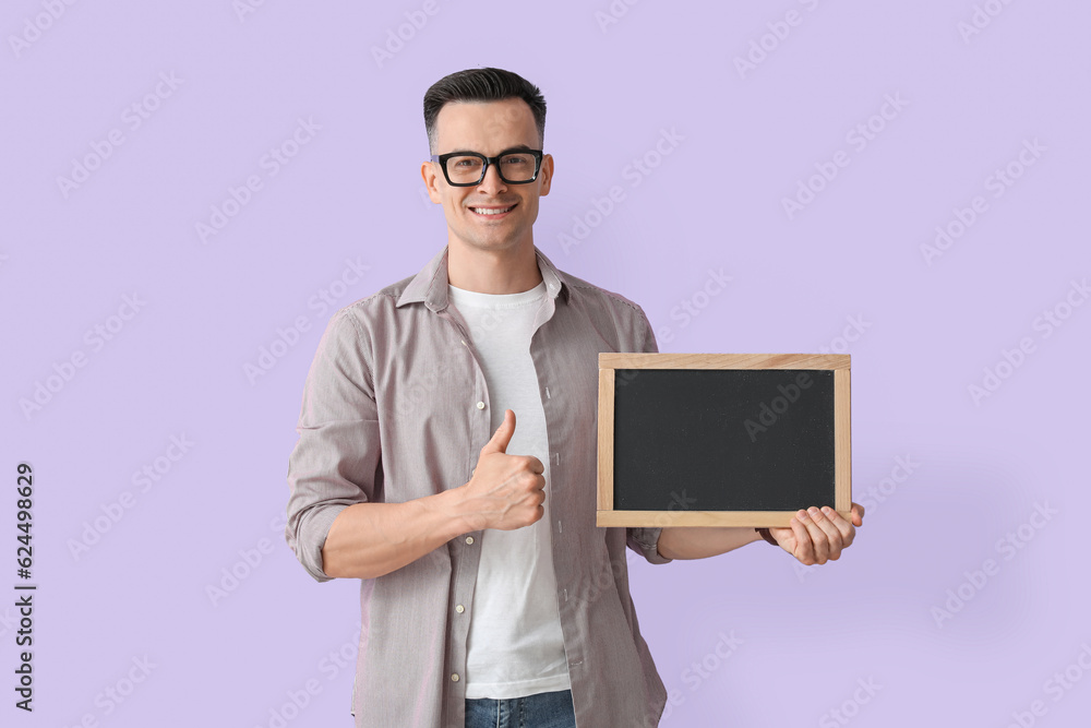 Male teacher with chalkboard showing thumb-up on lilac background