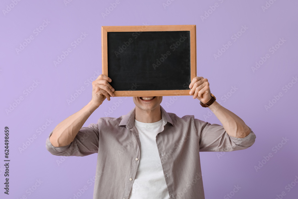 Male teacher with chalkboard on lilac background