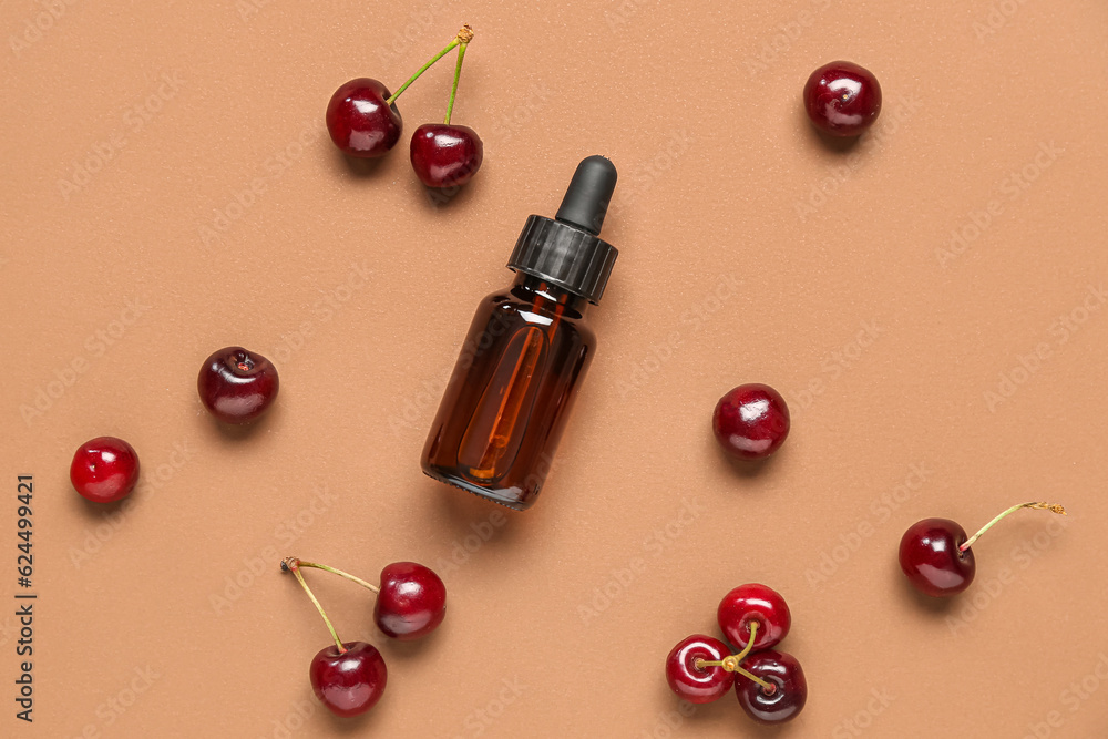 Composition with bottle of essential oil and sweet cherry on color background