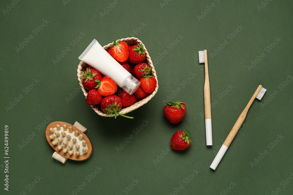 Composition with ripe strawberry, bath supplies and cosmetic product on green background