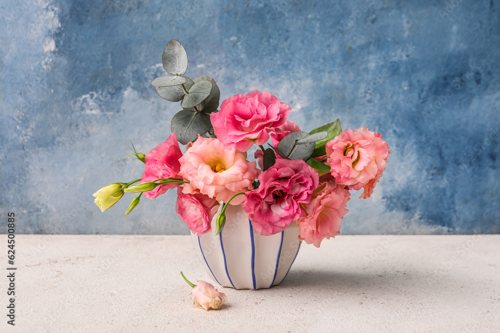 Vase with beautiful pink eustoma flowers on white table