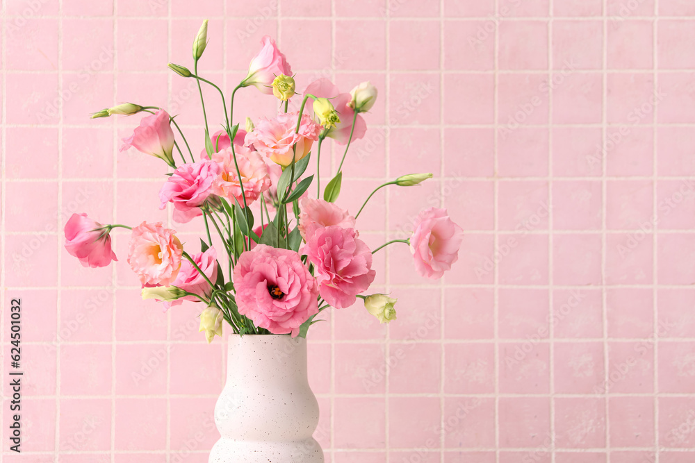 Vase with beautiful pink eustoma flowers on light tile background