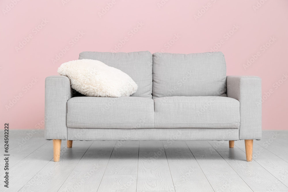 Interior of living room with sofa near pink wall