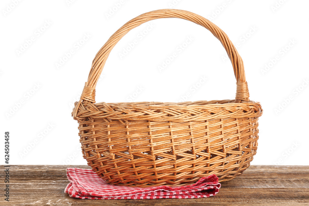 Wicker picnic basket and napkin on wooden table against white background