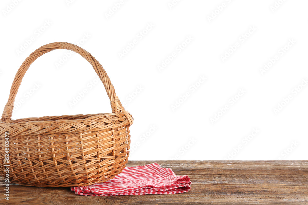 Wicker picnic basket and napkin on wooden table against white background