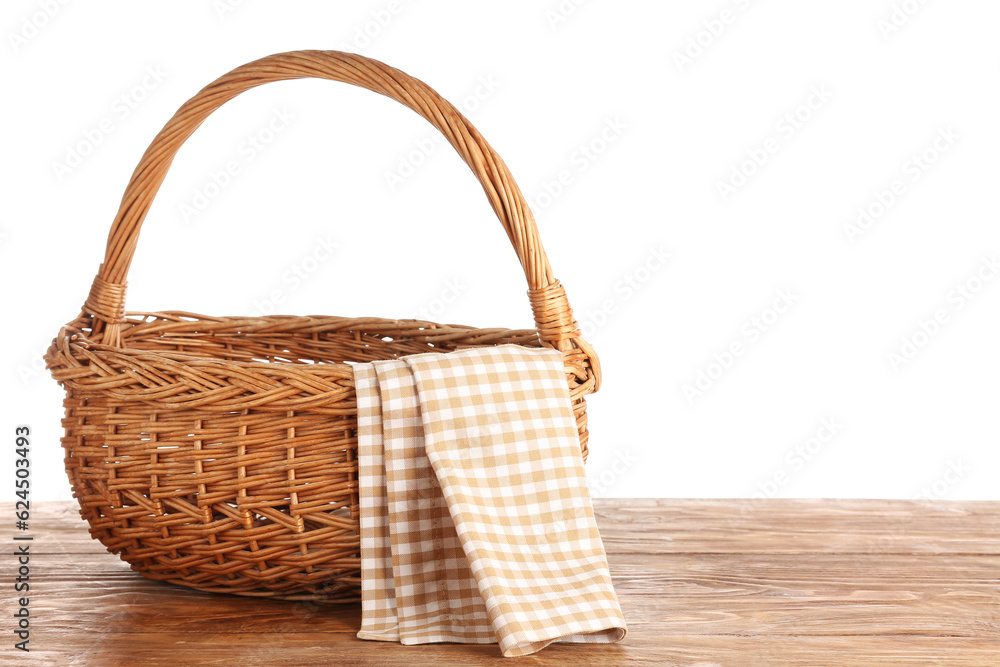 Wicker picnic basket with clean napkin on wooden table against white background