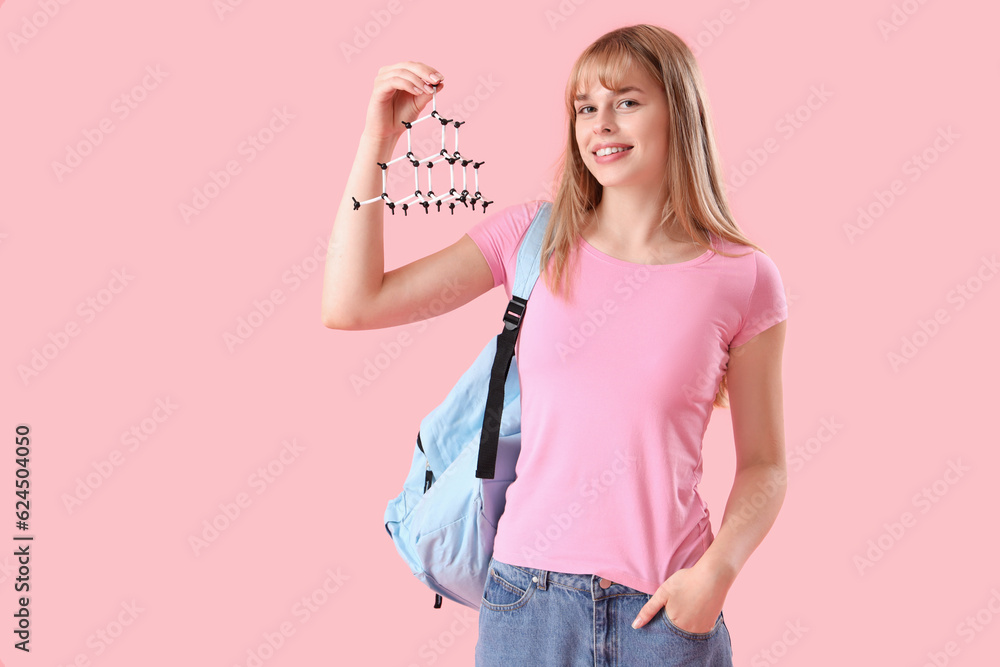 Female student with molecular model on pink background