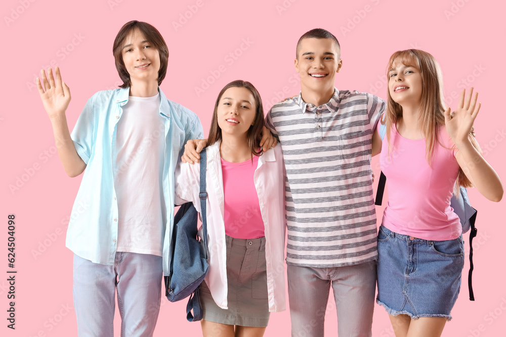 Group of teenage students on pink background