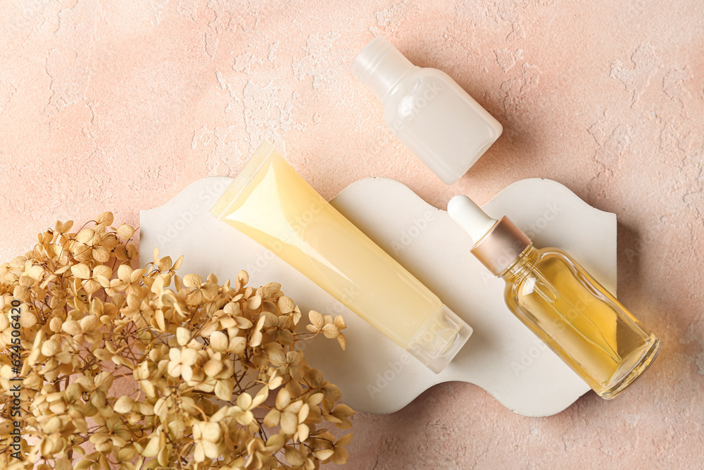 Composition with cosmetic products, plaster podium and dried hydrangea on color background