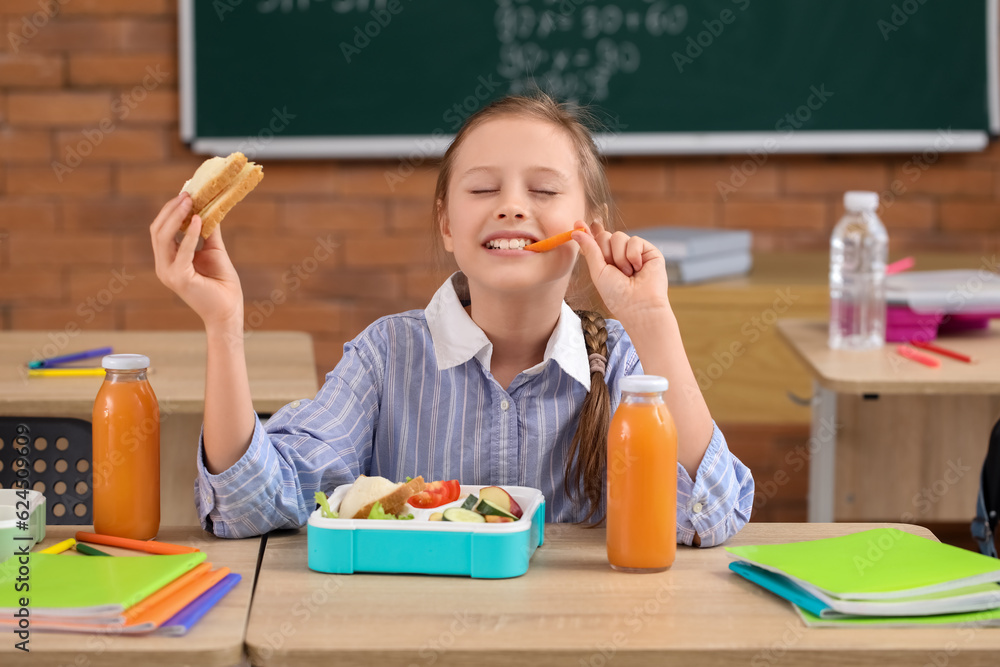 Little girl eating lunch in classroom