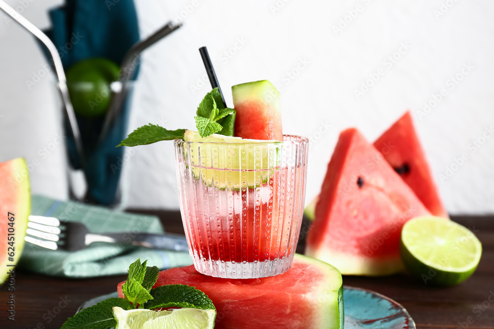 Glass of fresh watermelon lemonade with lime and mint on wooden table