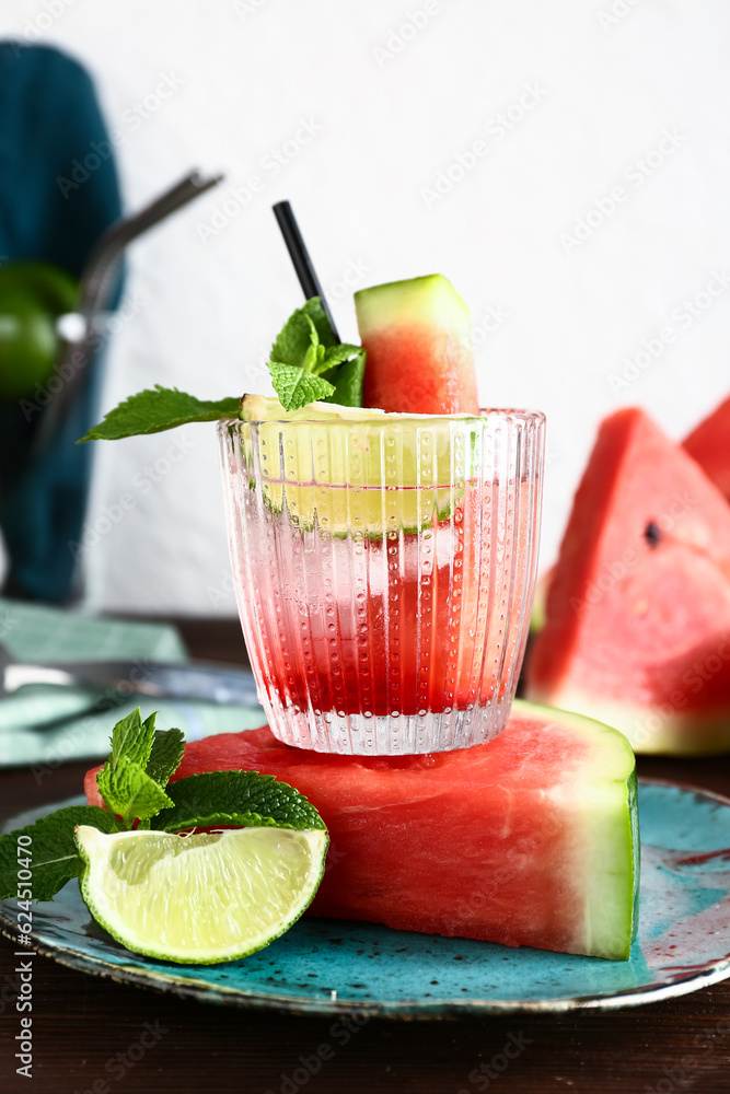 Glass of fresh watermelon lemonade with lime and mint on wooden table