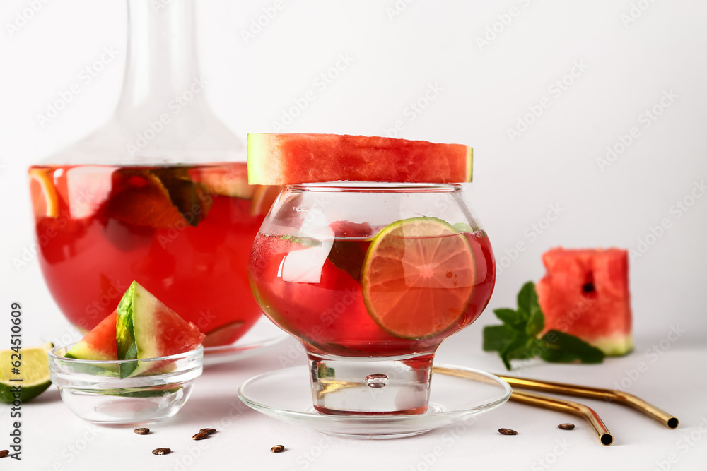 Glass and bottle of fresh watermelon lemonade with lime on white background