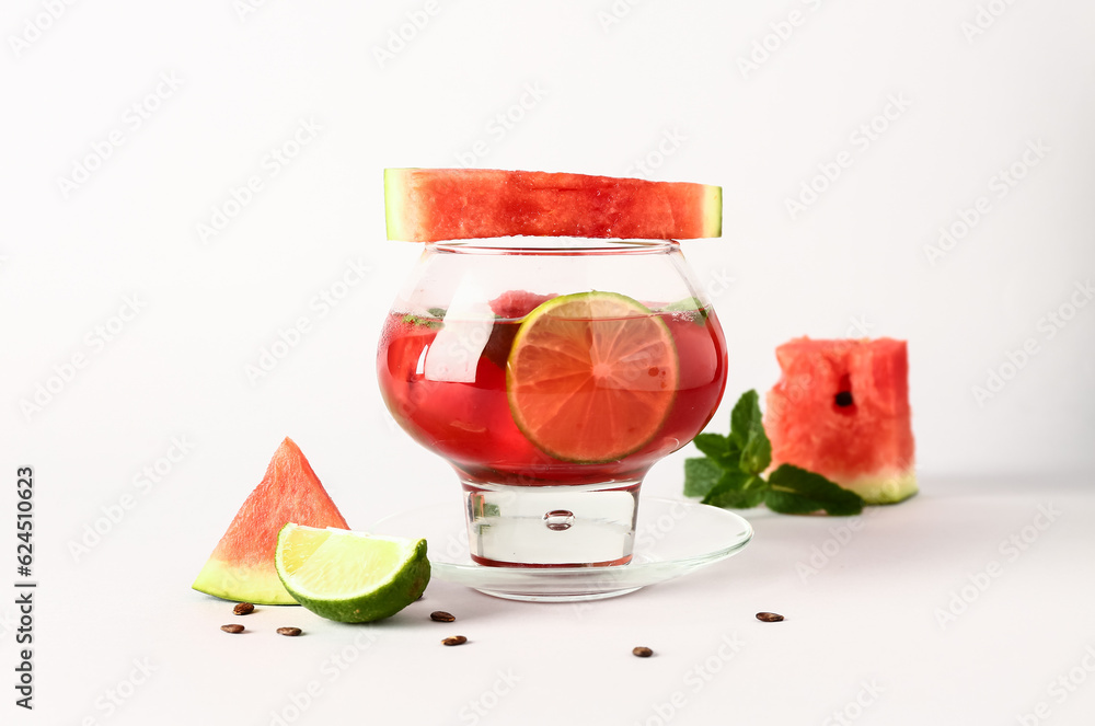 Glass of fresh watermelon lemonade with lime and mint on white background