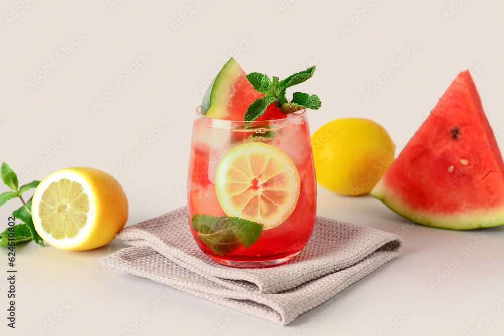 Glass of fresh watermelon lemonade with mint on white background