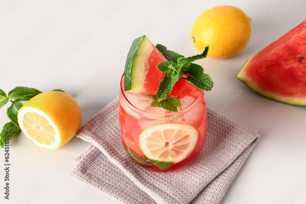 Glass of fresh watermelon lemonade with mint on white background