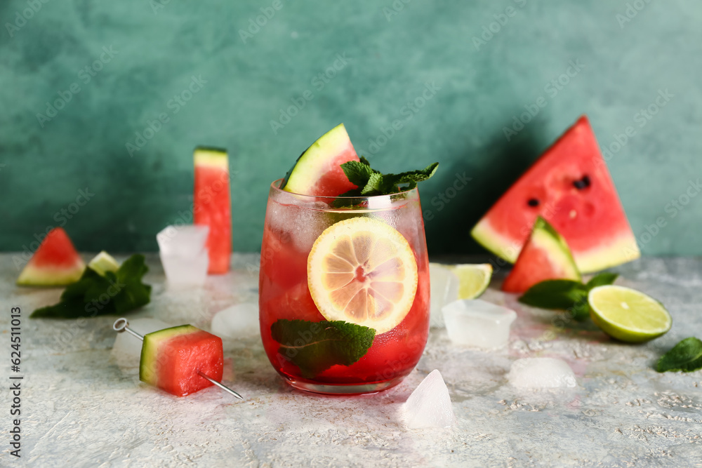 Glass of fresh watermelon lemonade with mint on grey table