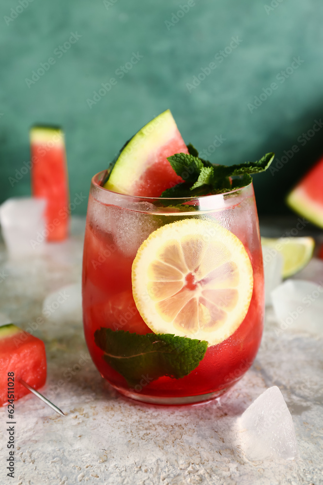 Glass of fresh watermelon lemonade with mint on grey table