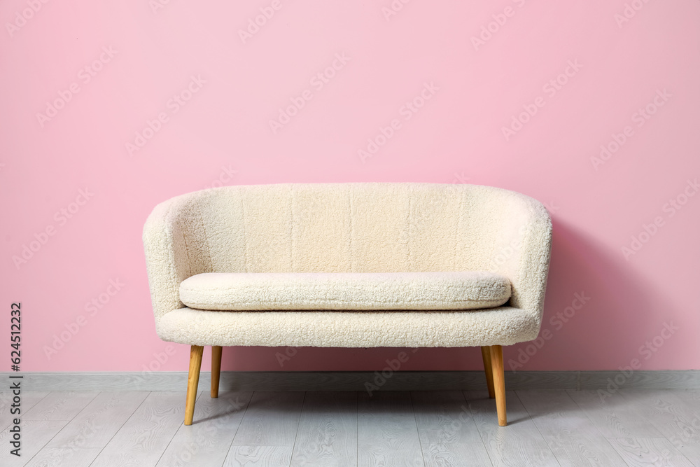 Cozy white sofa near pink wall