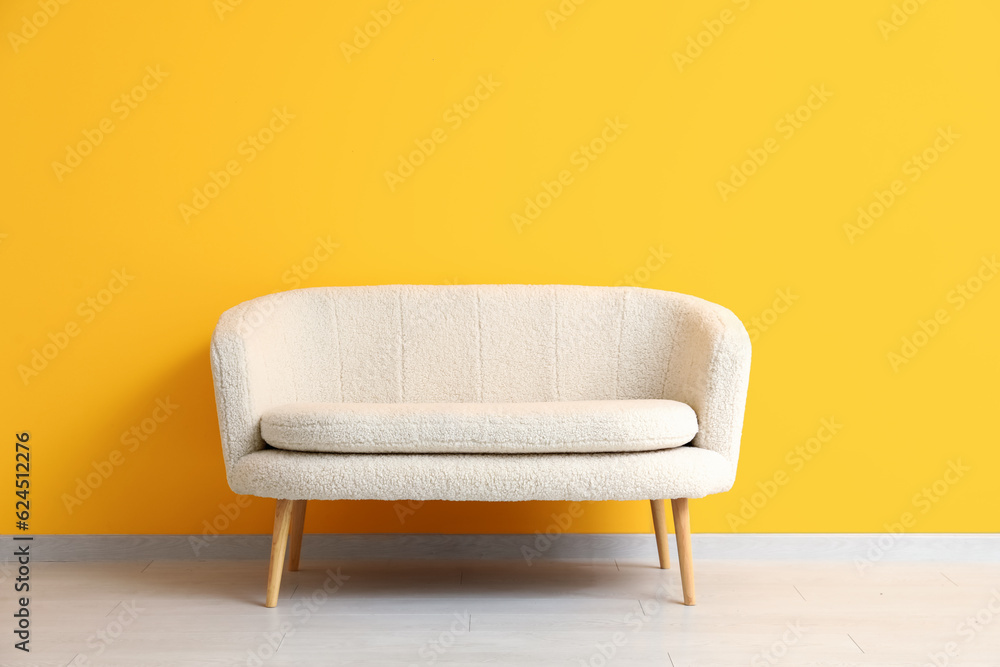 Cozy white sofa near orange wall