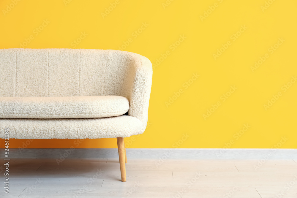 Cozy white sofa near orange wall