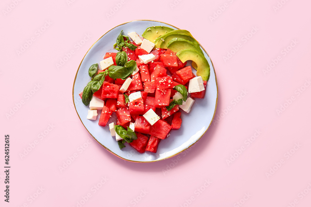 Plate of tasty watermelon salad on pink background