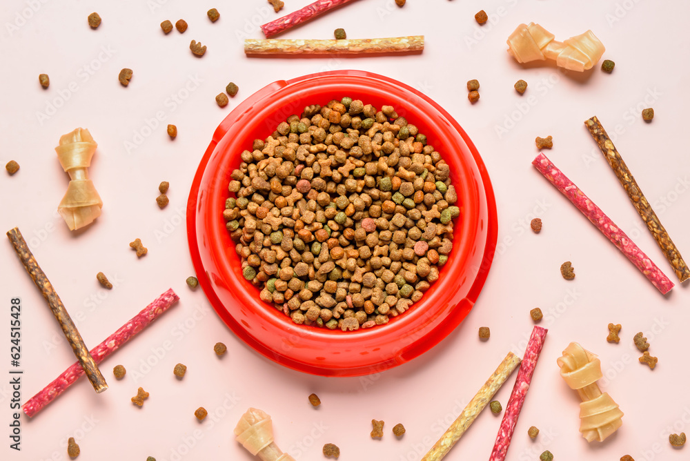 Composition with bowl of dry dog food and treats on light background