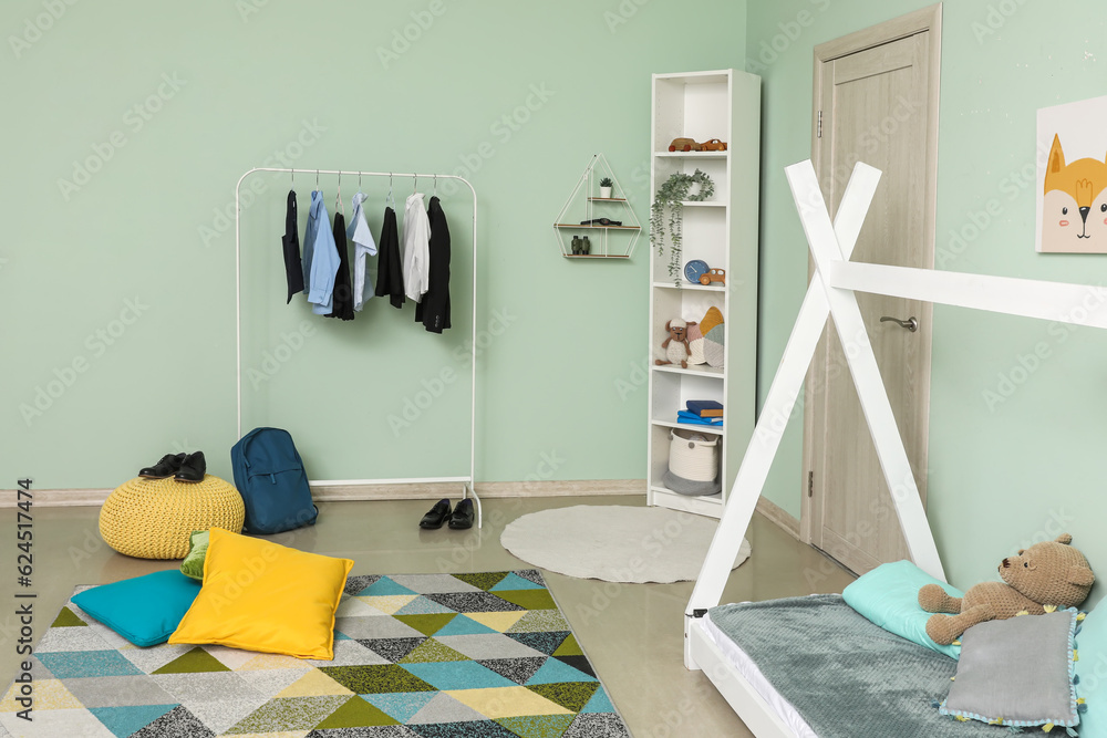 Stylish interior of childrens room with comfortable bed and school uniform