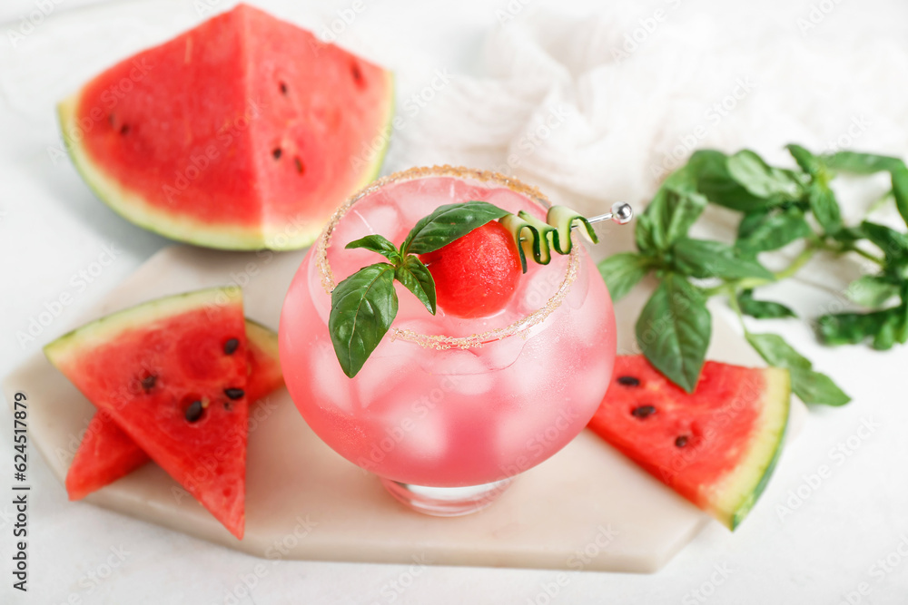 Board with glass of tasty watermelon cocktail and mint on white background