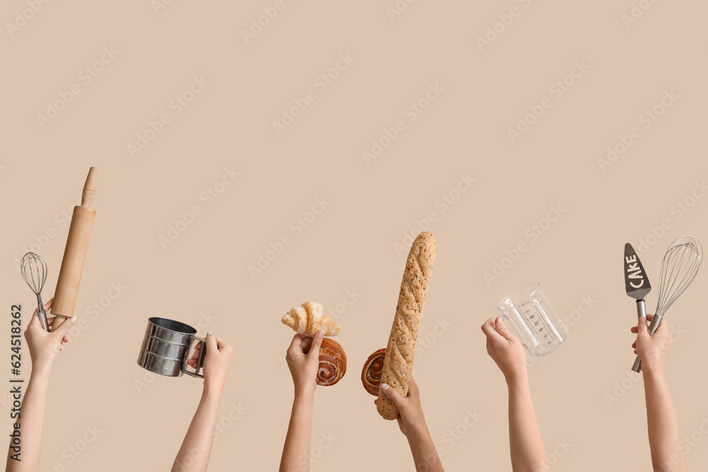 Female hands with baking utensils and different pastry on beige background