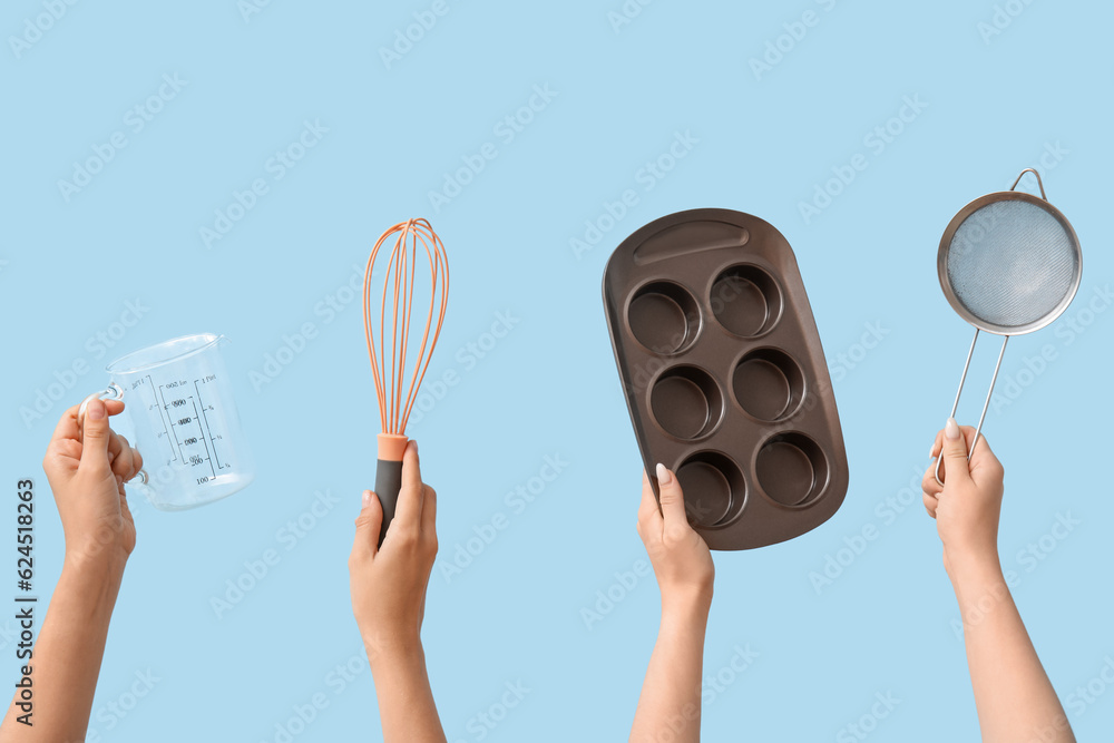 Female hands with baking utensils on blue background