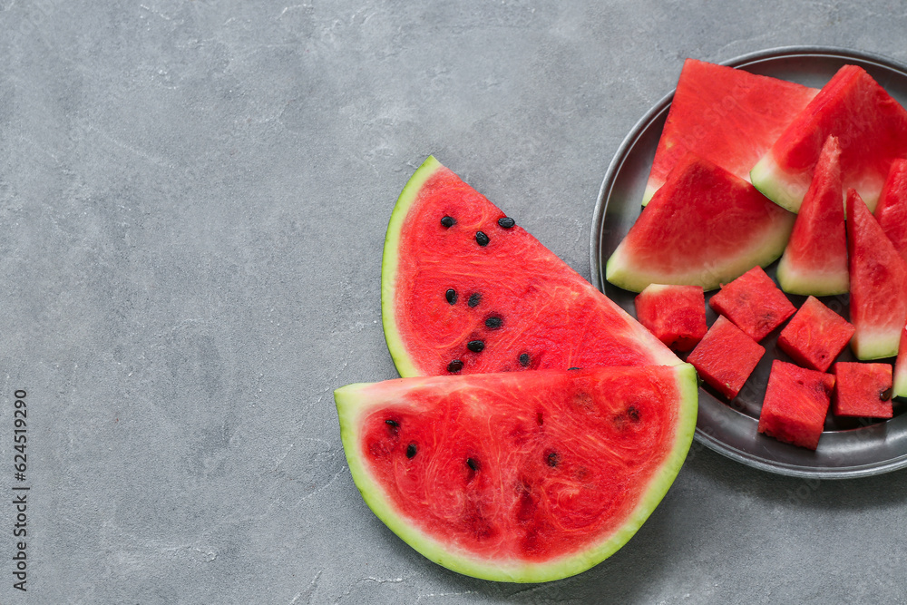 Plate with pieces of fresh watermelon on grey background