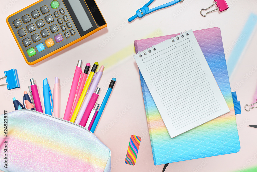 Composition with blank notebook and school stationery on pink background