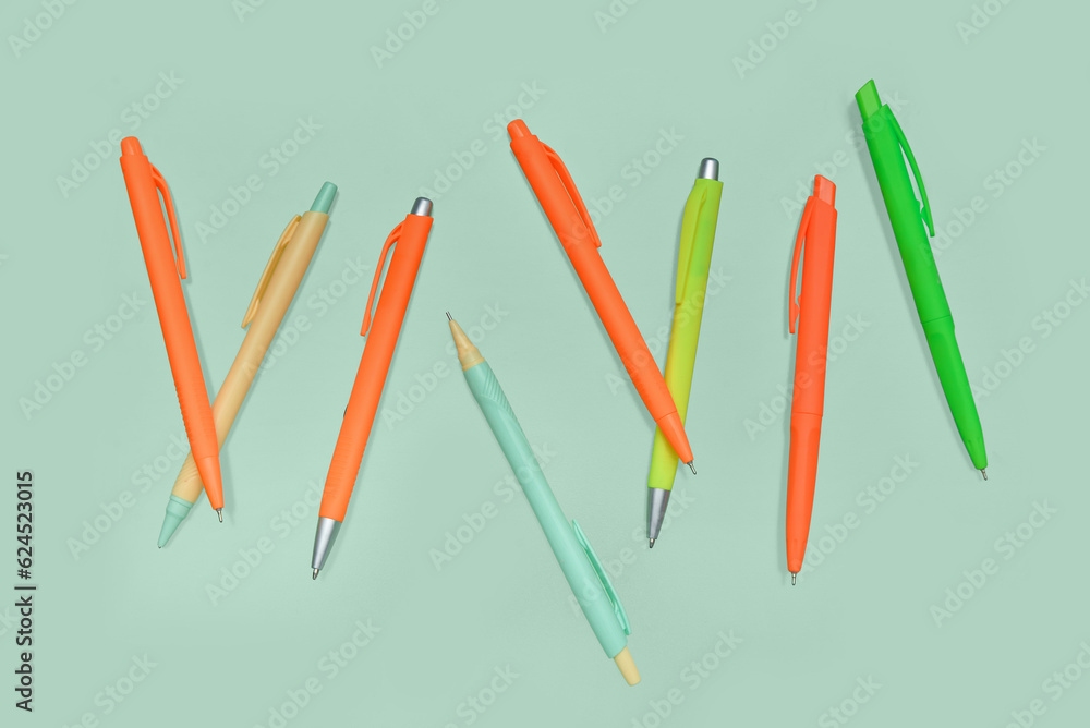 Colorful pens on green background