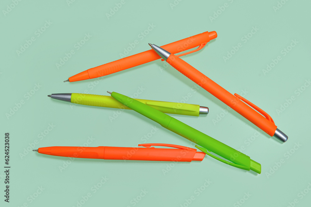 Colorful pens on green background