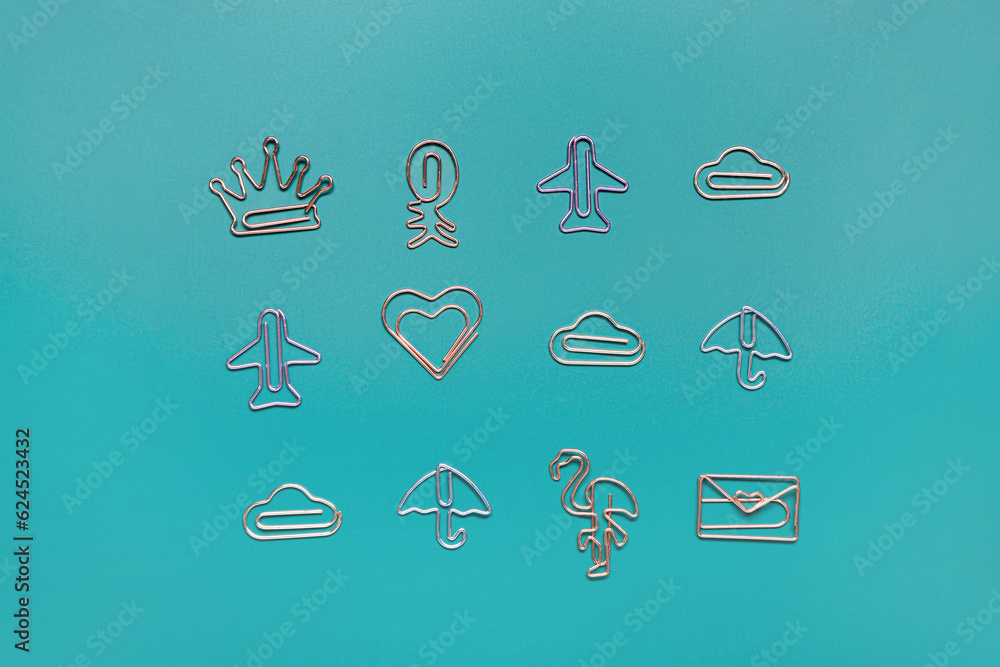 Paper clips in different shapes on blue background