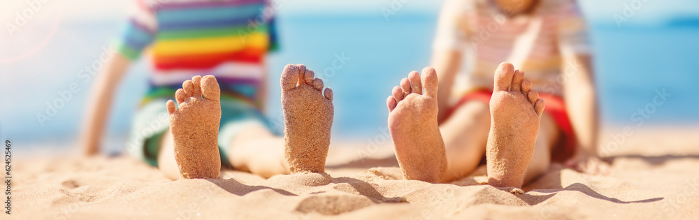 Children sitting on the sand on the beach near the sea.