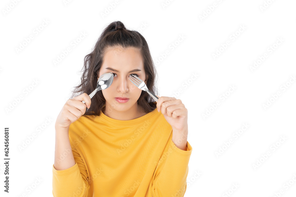 Young beauty Asian woman showing spoon and fork prepare to eat food and she wearing a yellow sweater